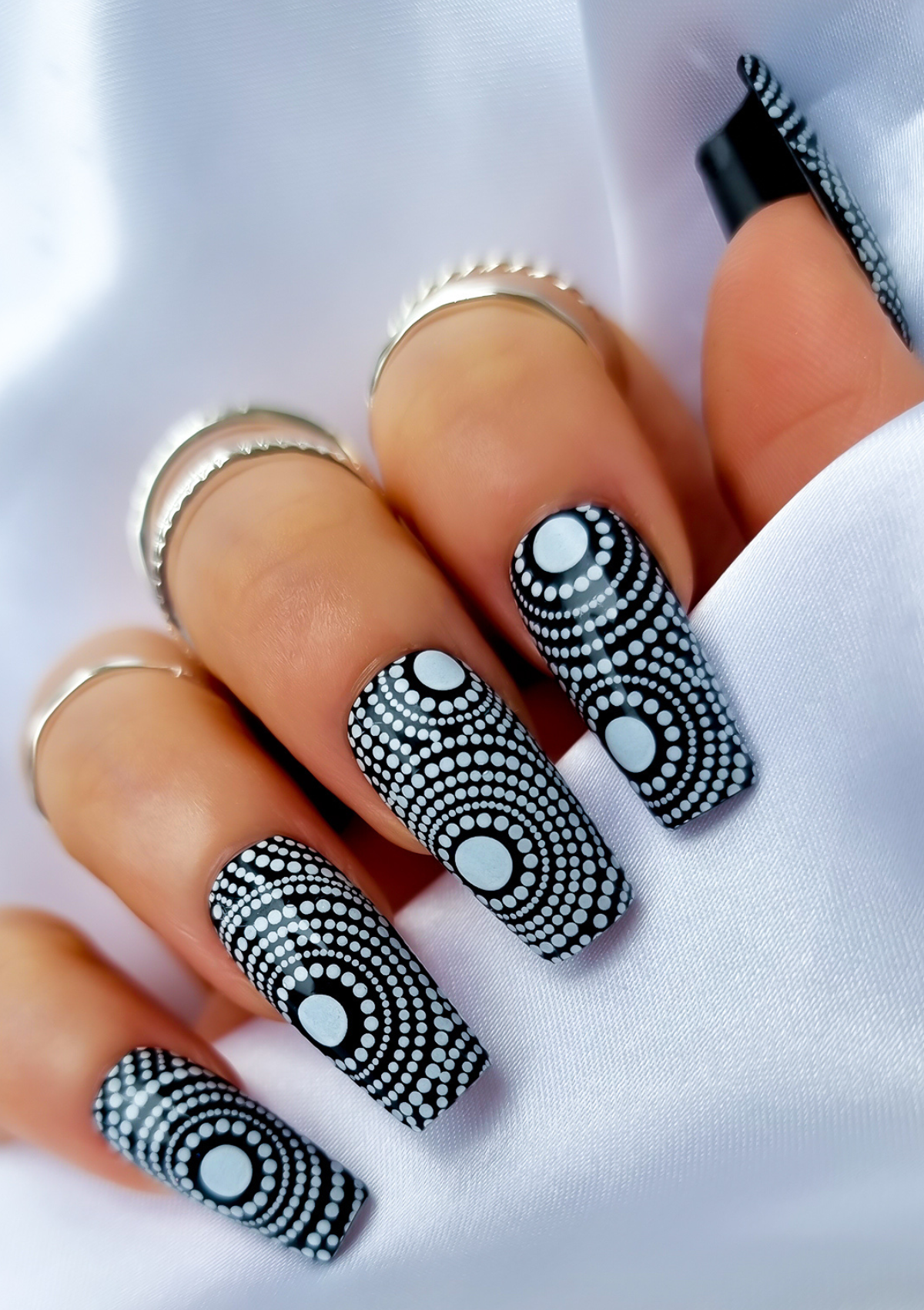 Black nails with white Aboriginal Australian nail art designs